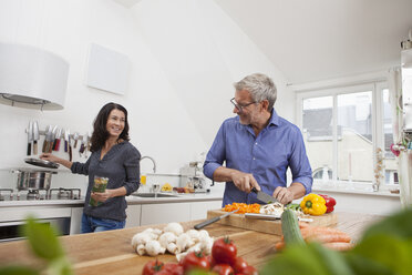 Mature couple preparing vegetables in kitchen - RBF003735