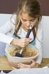 Little girl stirring dough - YFF000495