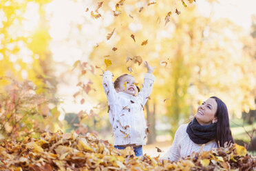 Happy girl with mother playing with autumn leaves - HAPF000059