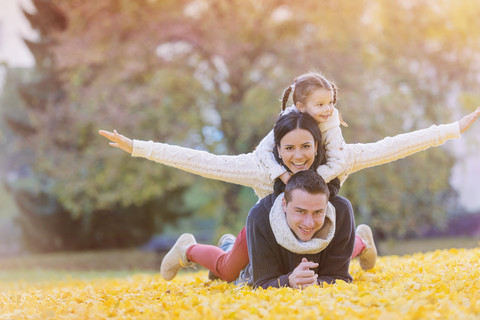 Glückliche Familie im Herbstlaub liegend, lizenzfreies Stockfoto