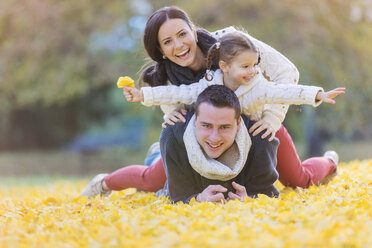 Happy family lying in autumn leaves - HAPF000070