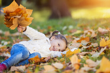 Happy girl lying in autumnal meadow - HAPF000077