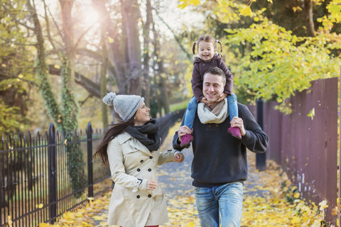 Family going for a walk in autumnal park stock photo
