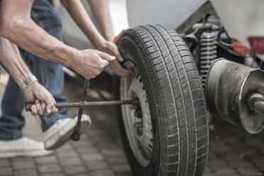 Großvater und Enkel wechseln Autoreifen - ZEF007638