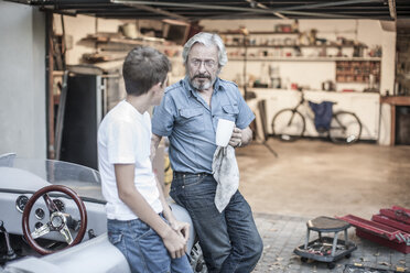 Großvater und Enkel machen eine Pause bei der Restaurierung eines Autos - ZEF007645