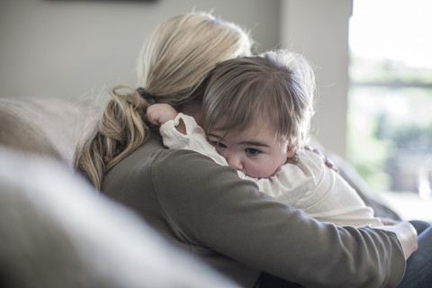 Mutter und kleines Mädchen kuscheln zu Hause, lizenzfreies Stockfoto