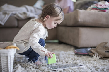 Baby girl playing with building blocks in living room - ZEF007678