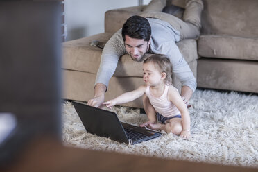 Vater und kleines Mädchen schauen auf den Laptop - ZEF007702