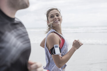 Young man and woman running on beach - ZEF007728