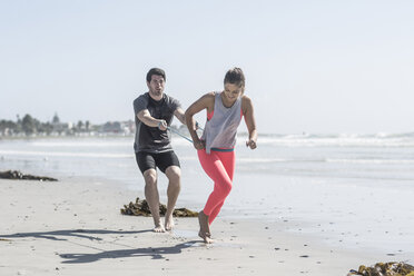 Junger Mann und Frau trainieren am Strand - ZEF007738