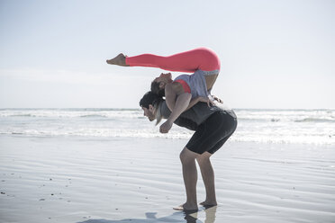 Young man and woman exercising on beach - ZEF007740