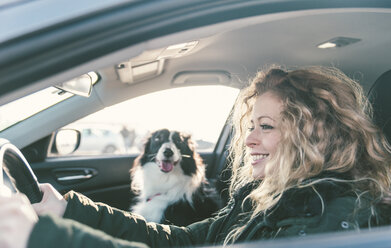 Frau fährt Auto, Hund sitzt auf dem Beifahrersitz - OIPF000032