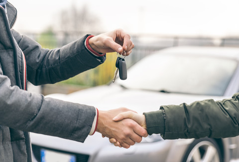 Two people reaching an agreement about a car sale stock photo