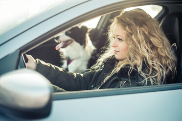 Frau fährt Auto, Hund sitzt auf dem Beifahrersitz - OIPF000036