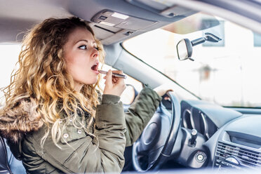 Frau trägt Lippenstift im Auto auf - OIPF000039