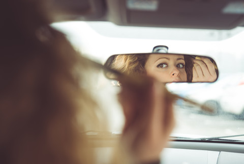 Frau trägt Make-up im Auto auf, lizenzfreies Stockfoto