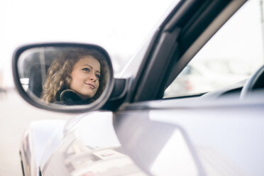 Frau fährt Auto, gespiegelt im Außenspiegel - OIPF000049