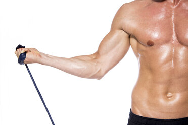 Hemdfreier muskulöser Mann beim Training mit Fitnessband vor weißem Hintergrund, Nahaufnahme - DAWF000393
