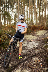 Mountain biker having a rest in the forest - MGOF001207