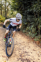 Mountainbiker beim Fahren im Wald - MGOF001213