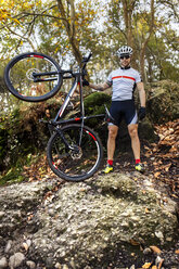Mountain biker with his bike in the forest - MGOF001214