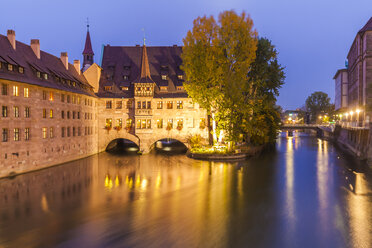 Germany, Bavaria, Nuremberg, Heilig-Geist-Spital on Pegnitz River in the evening - WDF003501