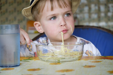 Porträt eines kleinen Jungen, der Spaghetti isst - ABAF001965