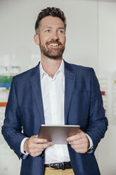 Junger Mann mit Tablet-PC im Büro stehend - MFF002541