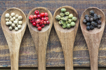 Row of four wooden spoons of different peppercorns - SARF002408