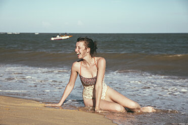 Brasilien, Bahia, lachende Frau am Meer sitzend - MFF002562