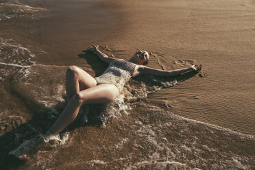 Brazil, Bahia, woman lying on wet sand at seafront - MFF002563