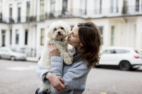 Young woman holding her dog on her arms - MAUF000182