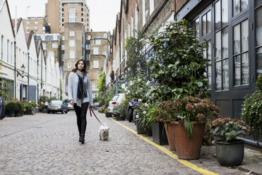 UK, London, young woman going walkies with her dog - MAUF000184