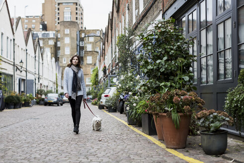 UK, London, junge Frau geht mit ihrem Hund spazieren - MAUF000184