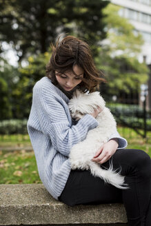 Young woman cuddling with her dog - MAUF000186