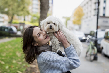 UK, London, glückliche junge Frau mit ihrem Hund - MAUF000187