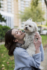 UK, London, happy young woman with her dog - MAUF000188