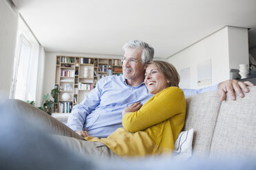 Smiling couple relaxing on the couch at home - RBF003749