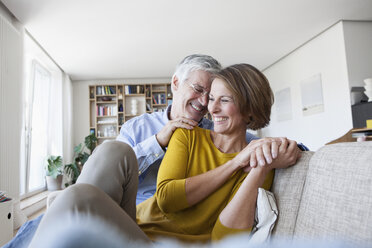 Glückliches Paar, das sich zu Hause auf der Couch entspannt - RBF003750