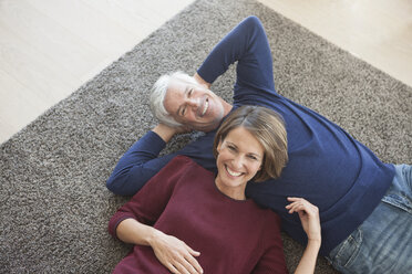 Happy couple relaxing together on the carpet - RBF003784