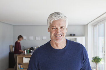 Porträt eines lächelnden Mannes mit grauem Haar und Bartstoppeln zu Hause - RBF003793