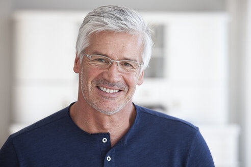 Porträt eines lächelnden reifen Mannes mit Bartstoppeln und Brille - RBF003815