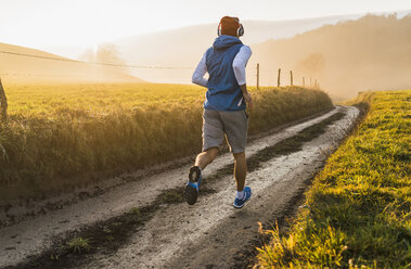 Junger Mann beim Joggen am Morgen - UUF006225