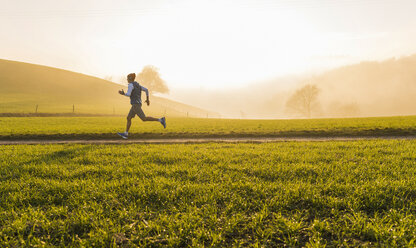 Junger Mann beim Joggen am Morgen - UUF006237