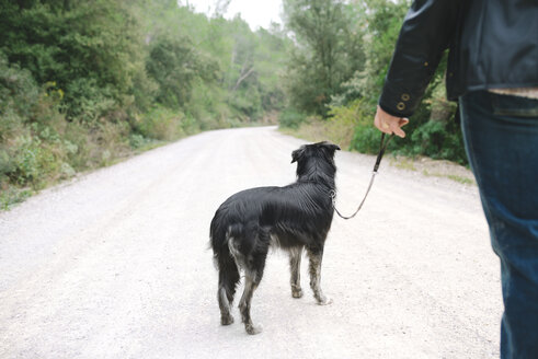 Frau geht mit ihrem Hund in der Natur spazieren - GEMF000578