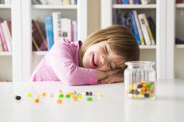 Porträt eines glücklichen kleinen Mädchens mit einem Glas Jelly Beans - LVF004343