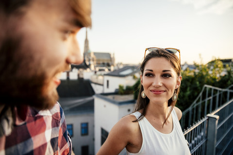 Austria, Vienna, portrait of smiling young woman face to face with her boyfriend on a roof terrace stock photo