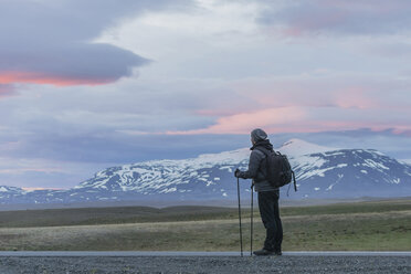 Iceland, Man standing on road looking at volcanos - PAF001520