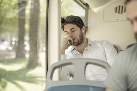 Young man sleeping in city bus stock photo