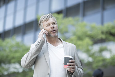 Mature man talking on the phone, holding coffee cup - ZEF007764